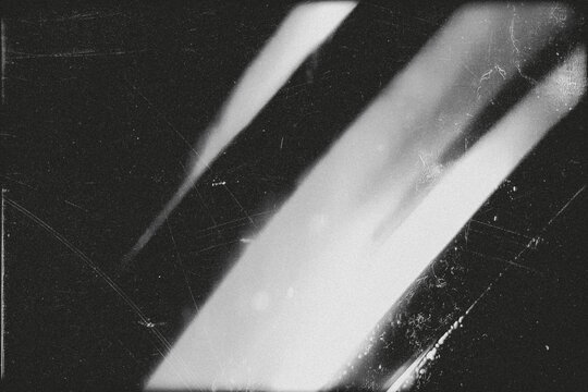 retro film overlay effect with scratch dust and motion blur light leaks, retro grain noisy film distressed texture light leak flare on black background,black and white abstract light background - Powered by Adobe
