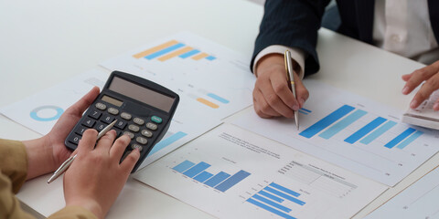 Financial Analysis. Professional using calculator for data evaluation in a business meeting.