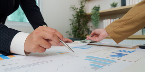 Financial Consultation. Professionals discussing financial data with charts and graphs.
