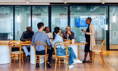 Group of diverse professionals engaging in discussion at a shared office table