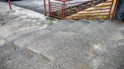 Outdoor Exposed Aggregate Concrete Stairs and Landing with Rust-Colored Metal Railing: Texture, Construction, and Urban Architecture Detail