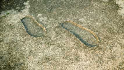 Permanent Footprints Embossed in Aged Concrete: Abstract Concept of Historical Mark, Legacy, and Lasting Impression
