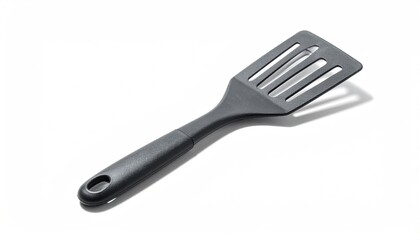 Black slotted spatula resting diagonally on white surface