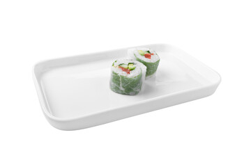 angled view of salmon avocado sushi rolls wrapped in green cabbage