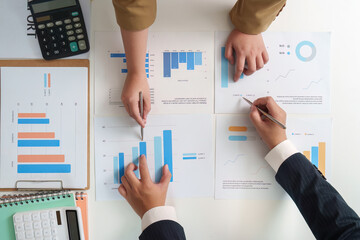 Data Analysis. Team reviewing financial graphs and statistics on a table.
