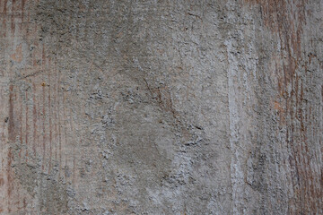 Old wooden plank wall showing weathered gray concrete texture, creating background with rough surfaces, cracks, and grunge patterns