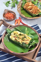 Grilled rice with basil chicken, wrapped in banana leaves, a traditional Indonesian dish
