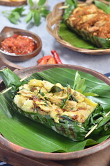 Grilled rice with basil chicken, wrapped in banana leaves, a traditional Indonesian dish