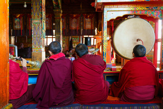 Monks play traditional instruments inside a temple