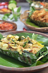 Grilled rice with basil chicken, wrapped in banana leaves, a traditional Indonesian dish