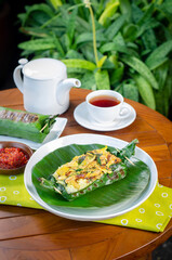 Grilled rice with basil chicken, wrapped in banana leaves, a traditional Indonesian dish