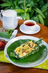 Grilled rice with basil chicken, wrapped in banana leaves, a traditional Indonesian dish