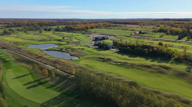 A high-angle aerial view of the TPC Toronto at Osprey Valley, showcasing its challenging, links-style layout with rolling fescue, water hazards, and pristine greens in peak autumn.