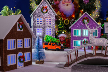 A village with beautiful multi-colored houses with illuminated windows and a bridge with a deer in the center