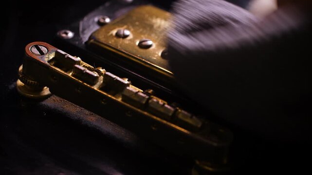 Close up shot the hand using microfiber fabric to clean the fret board of electric guitar