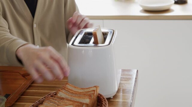 Closeup man using toaster in the kitchen