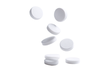 White, round tablets scattered in mid-air