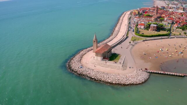 4k drone flight moving to the side footage (Ultra High Definition) of  Madonna dell'Angelo church - small seaside chapel and pilgrimage destination, Caorle resort, Italy, Europe.