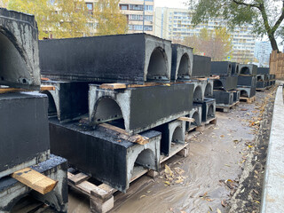 Precast Concrete Cable Troughs with black waterproofing folded in city street. Renovation urban...