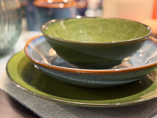 Stacked ceramic bowls and plates in green and blue