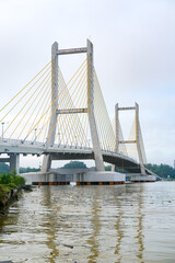 Cable-stayed bridge spanning across Kendari Bay, showcasing modern engineering and elegant design that connects the city’s shores with scenic reflection on calm waters.