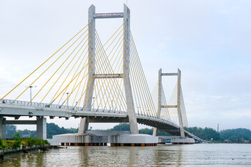 Cable-stayed bridge spanning across Kendari Bay, showcasing modern engineering and elegant design that connects the city’s shores with scenic reflection on calm waters.