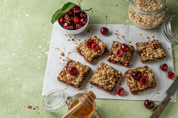 Cherry oatmeal crumble bars. Backed cherry crisp. Quick and easy homemade sweet red berry squares with streusel. Crumble fruit cake or pie. Wholesome and healthy breakfast. Home cooking. Copy space.