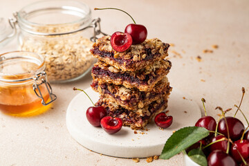Stack of baked oatmeal crumble squares with fresh cherry. Cherry oatmeal crumble bars. Quick and easy homemade red berry pie with streusel. Crumble fruit cake. Home cooking.