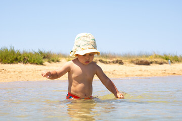 Child playing in shallow beach water