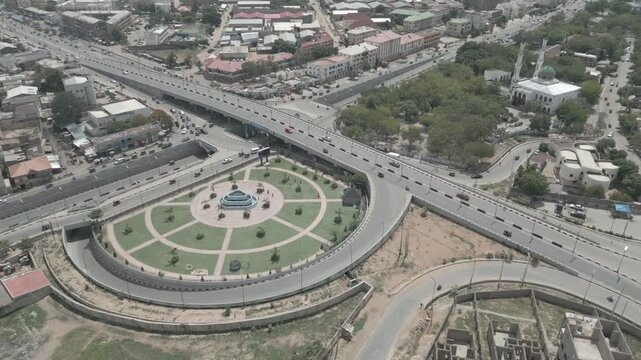 Aerial view of the RMK Bridge reveals a bustling cityscape with roads, roundabout, and a mosque, showcasing urban life, Kano, Kano, Nigeria.