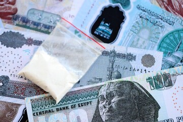 Egyptian pound currency money bills and cocaine pack close up. The concept of drug trafficking