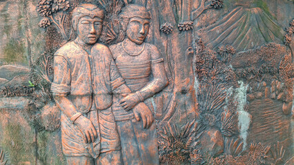 Ancient Wall Relief of Baturaden Folklore Couple Walking in Forest with Mount Slamet in Background