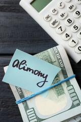 Note with word Alimony, money and calculator on wooden table, flat lay