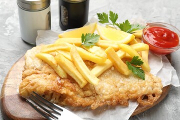 British Traditional Fish and chips served with sauce on gray table, closeup
