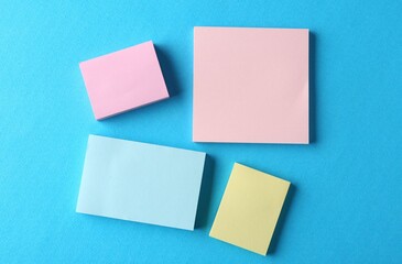 Blank colorful notes on light blue background, flat lay. Space for text