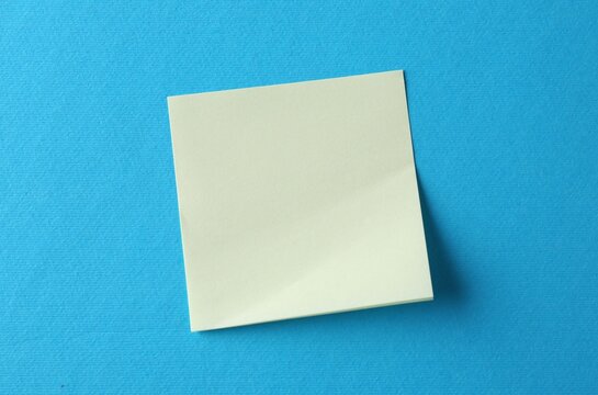 Blank yellow notes on light blue background, top view. Space for text