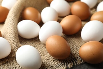 Many raw chicken eggs on grey table, closeup