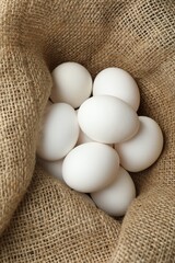 Many raw chicken eggs in sack, closeup