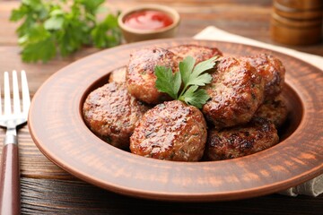 Delicious meat patties served on wooden table, closeup