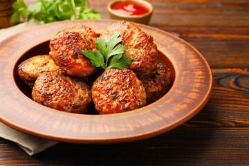 Delicious meat patties served with sauce on wooden table, closeup