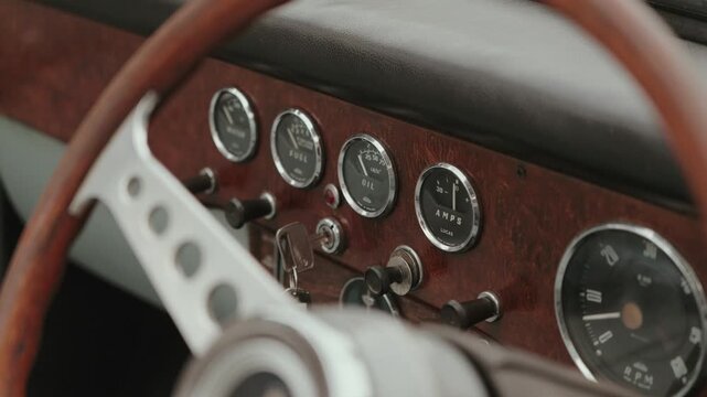 Close up of retro car interior showing wooden panel and gauges