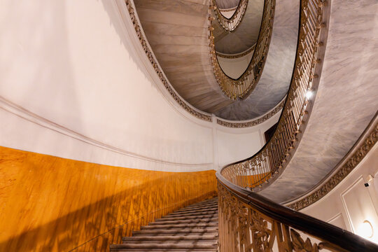 Grand marble spiral staircase with ornate railings in Naples Italy