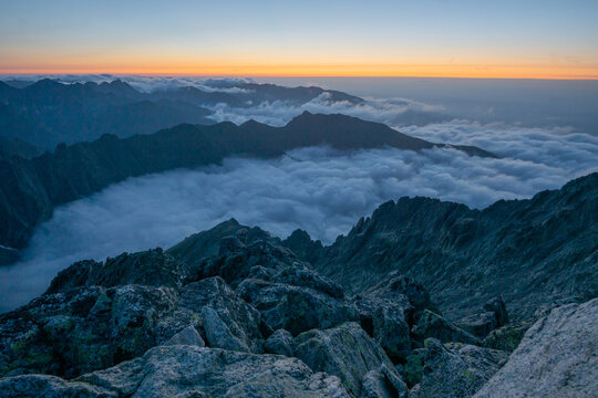 Aerial view of Maly Ladovy stit piercing through a sea of clouds under the glow of dawn's first light, Tatranska Javorina, Presov Region, Slovakia.