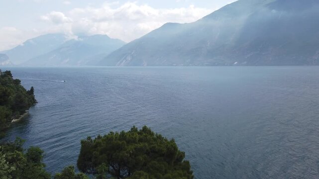 Aerial shot of Lake Garda springtime with ferry cruising near Limone shores