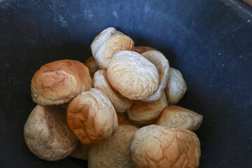 Pile of freshly baked, warm, golden brown bread rolls sitting in dark bowl. comforting and delicious sight of simple, homemade food ready for meal