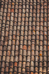 Beautifully aged terracotta tiles create a stunning rustic pattern on a rooftop under soft sunlight in a quaint village setting