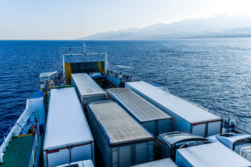 Obraz premium naval transport cargo ferry ship transporting wagon trucks to a destination port to supply trade goods to commercial sea port throuth sea and ocean