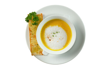 A close-up overhead shot of creamy soup in a white bowl, served with toast