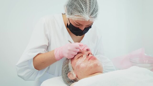 Beautician gently and skillfully removing skin impurities enhancing complexion. Female focusing on facial treatment applying professional techniques. Girl experiencing meticulous care aimed at