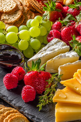 Indulge in a vibrant cheese board feast featuring ripe strawberries, crisp grapes, creamy brie, and artisanal crackers, perfect for elegant entertaining.